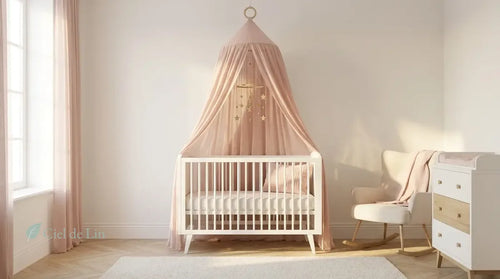 Chambre bébé fille douce en rose poudré avec ciel de lit gaze coton suspendu à anneau bois naturel