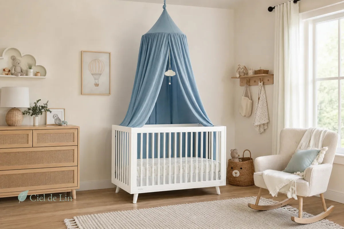 Chambre de bébé avec lit blanc et ciel de lit bleu suspendu au plafond dans une nursery lumineuse