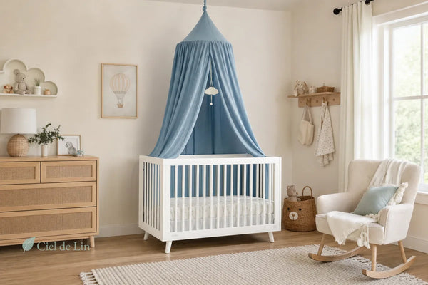 Chambre de bébé avec lit blanc et ciel de lit bleu suspendu au plafond dans une nursery lumineuse